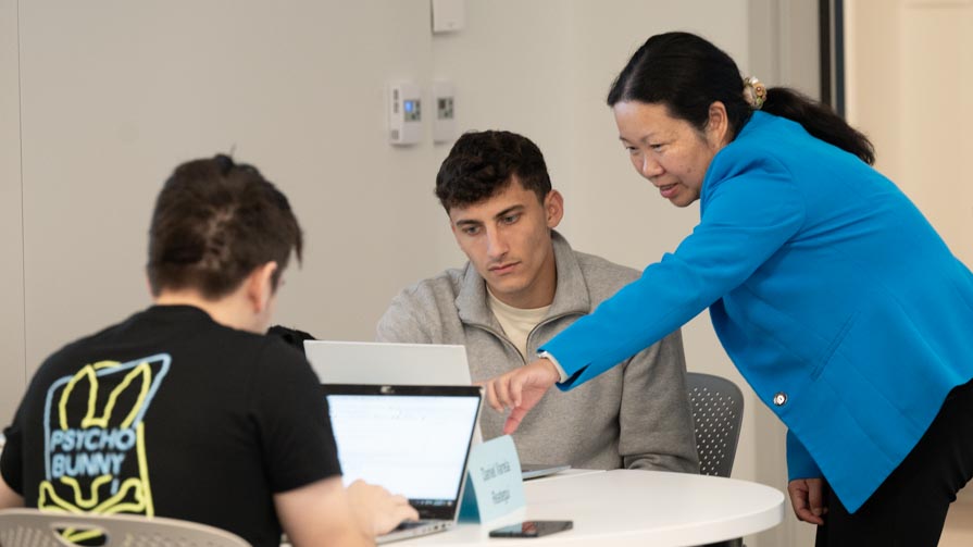  Professor and the Chair of the Information Systems and Analytics department Suhong Li offers guidance to a student in Bryant University's new Data Science Lab.